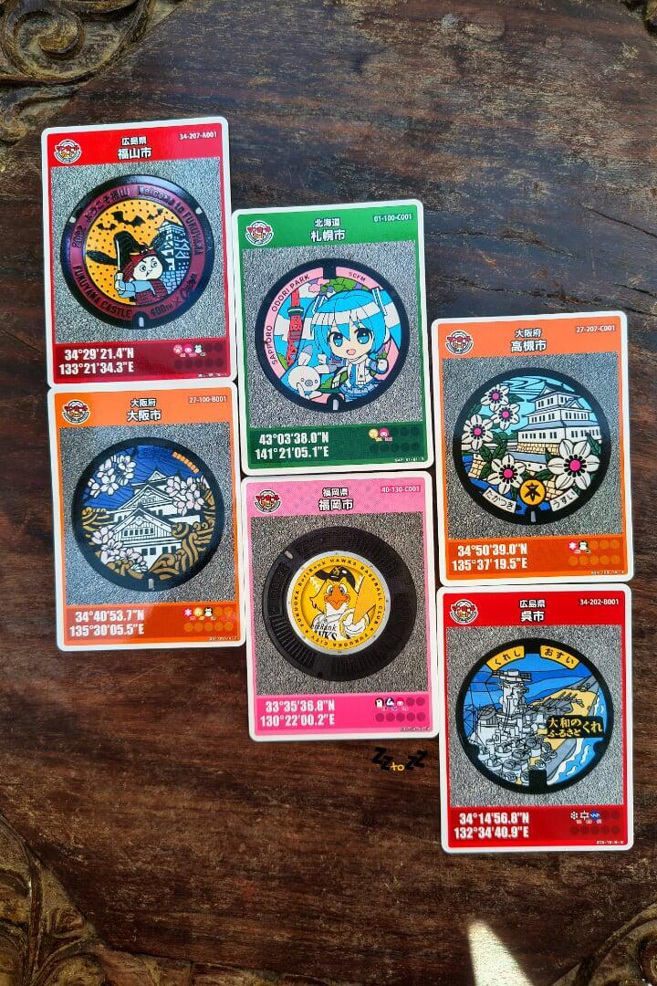 manohole collectible cards placed on a wooden table